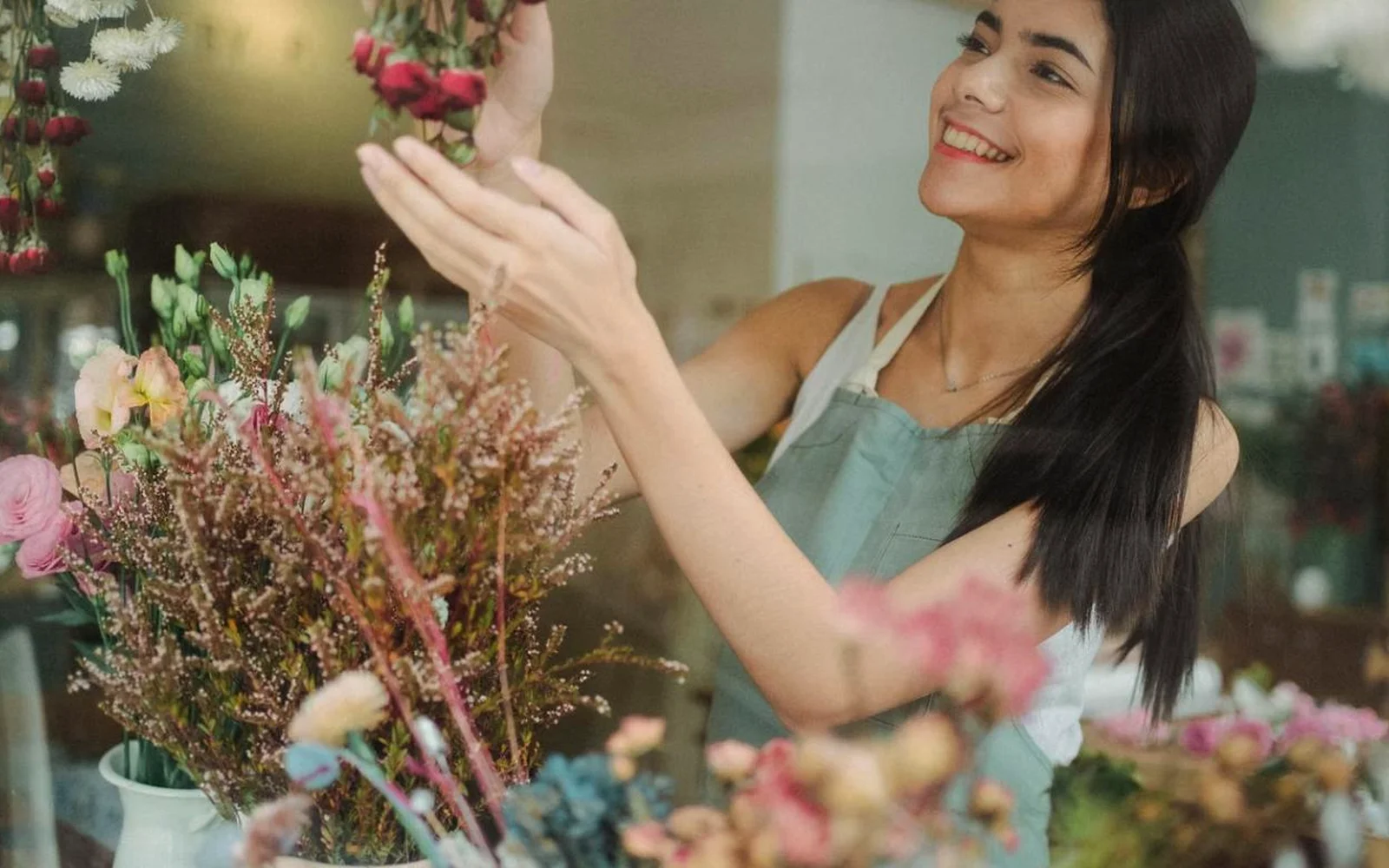 Dueña de un pequeño negocio arreglando flores en su tienda